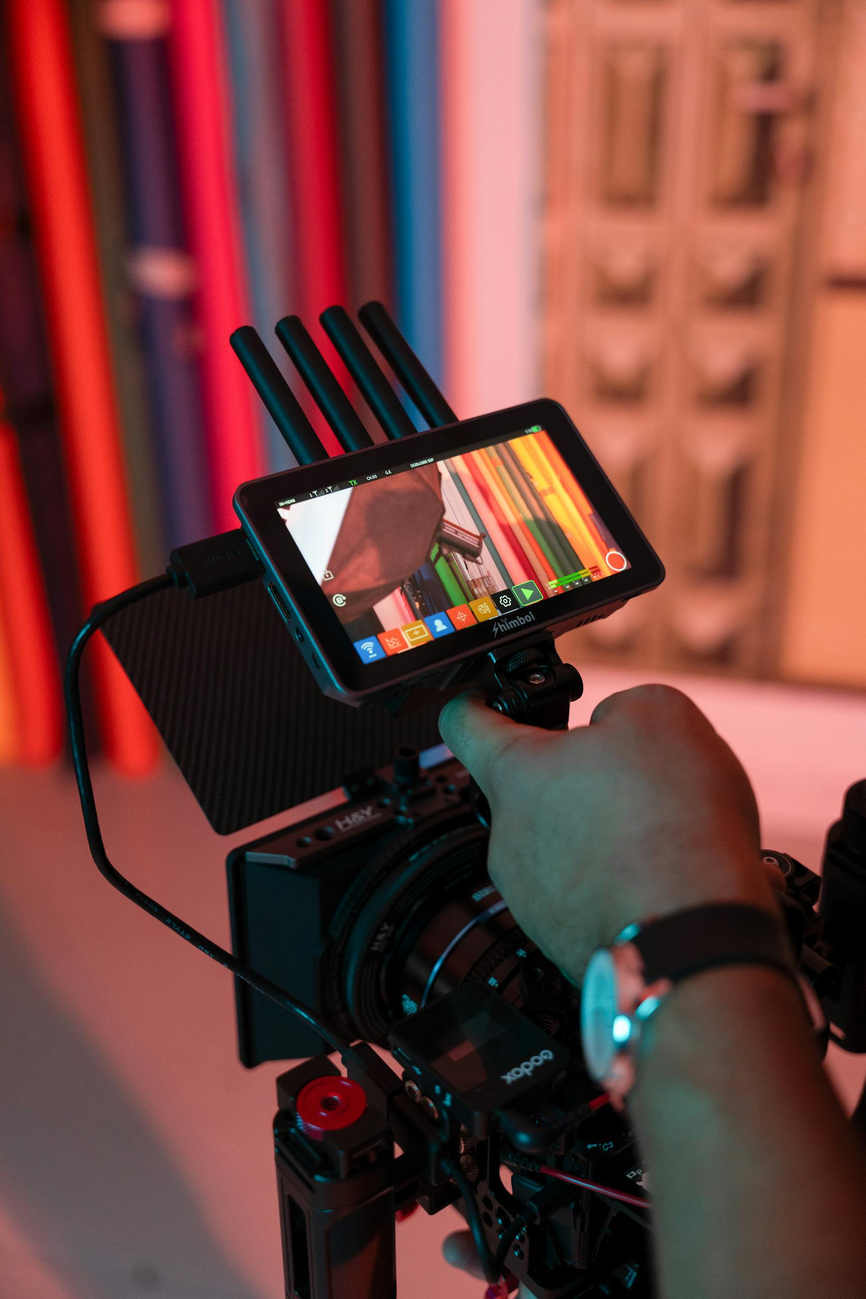 Close-up of a professional camera setup in a vibrant studio with colorful backgrounds.