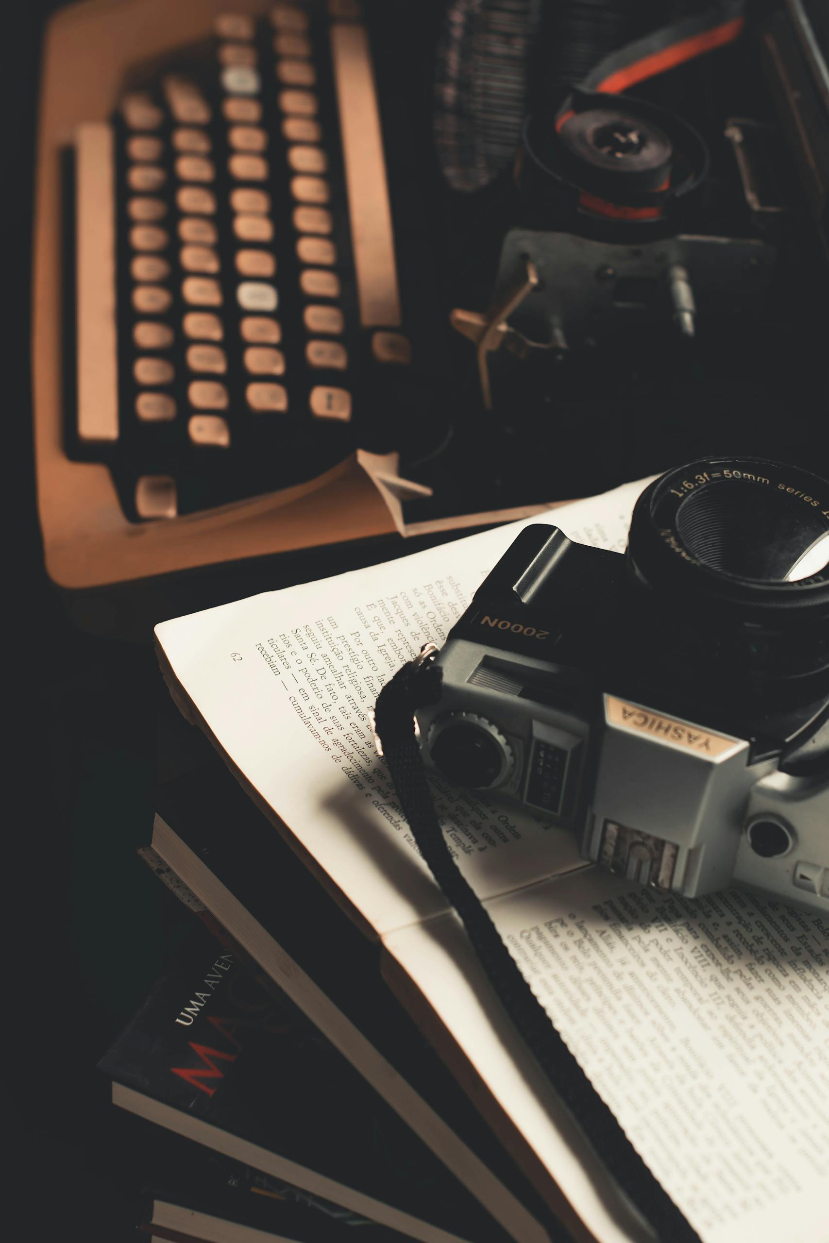 Retro scene featuring a vintage camera and typewriter on an open book.